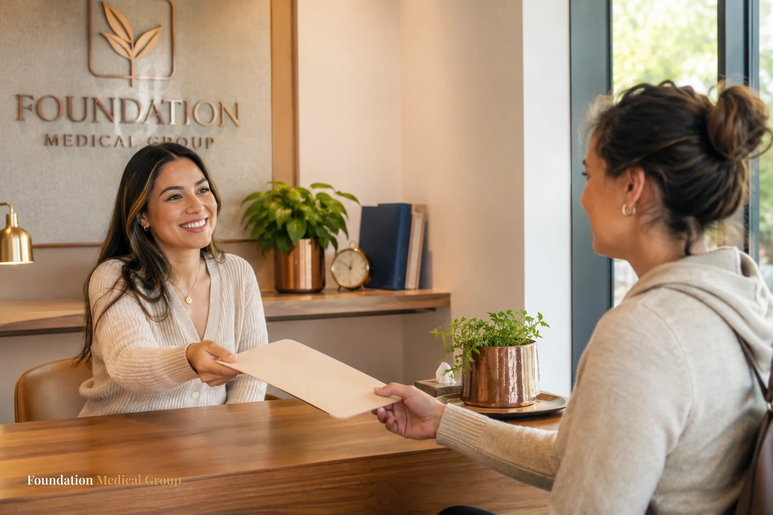 A caring coordinator hands a patient a simple folder of resources across a bright desk with warm wood tones and a small 
